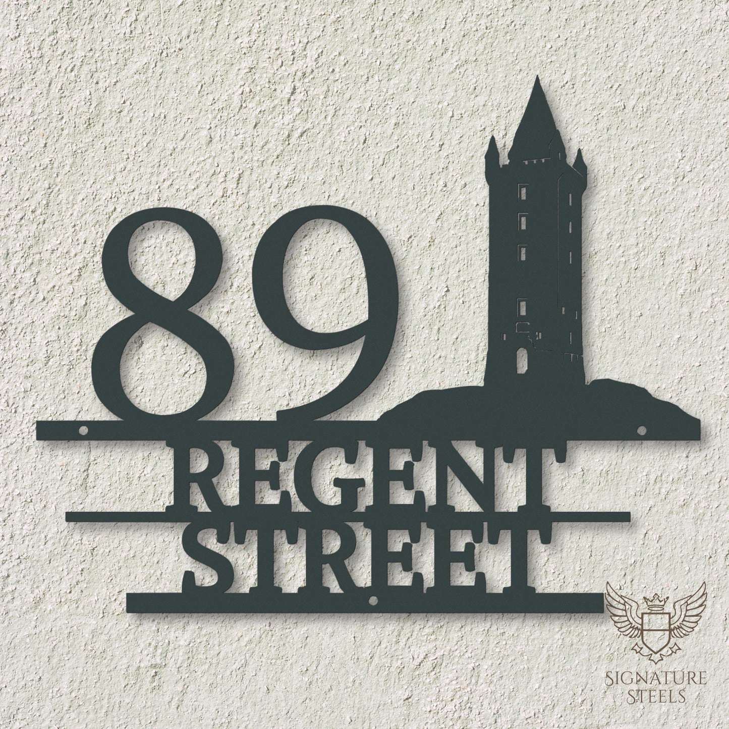 Anthracite metal address sign with house number 89, street name Regent Street, horizontal parallel lines and a silhouette of Scrabo Tower, a landmark of Newtownards in Northern Ireland, hanging on an off-white concrete wall.