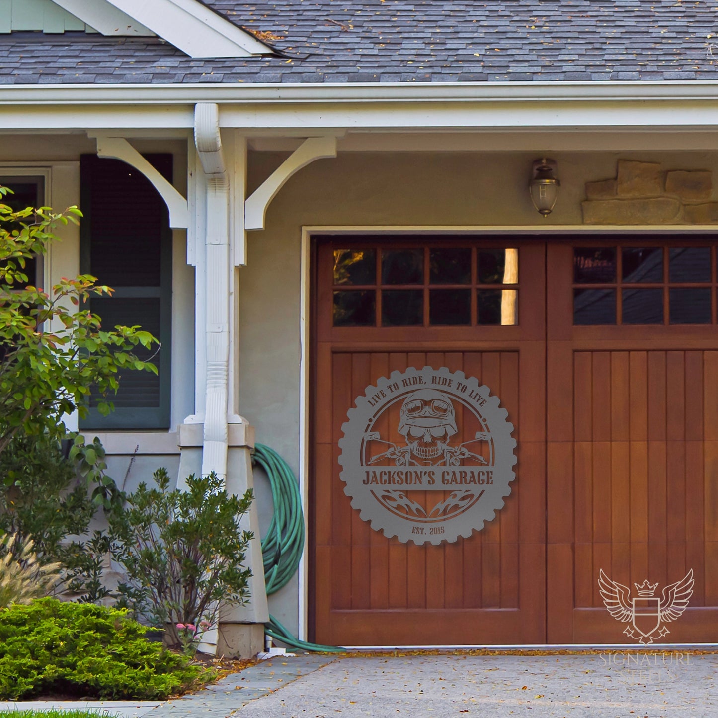 A metal sign with a skull and flames hanging on a garage door.