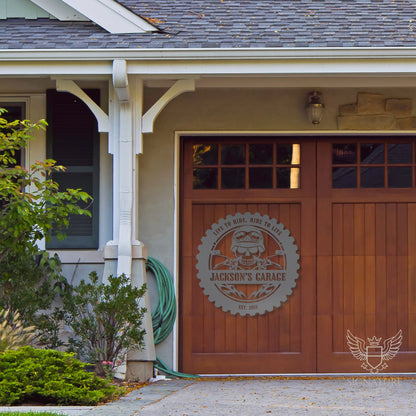 A metal sign with a skull and flames hanging on a garage door.
