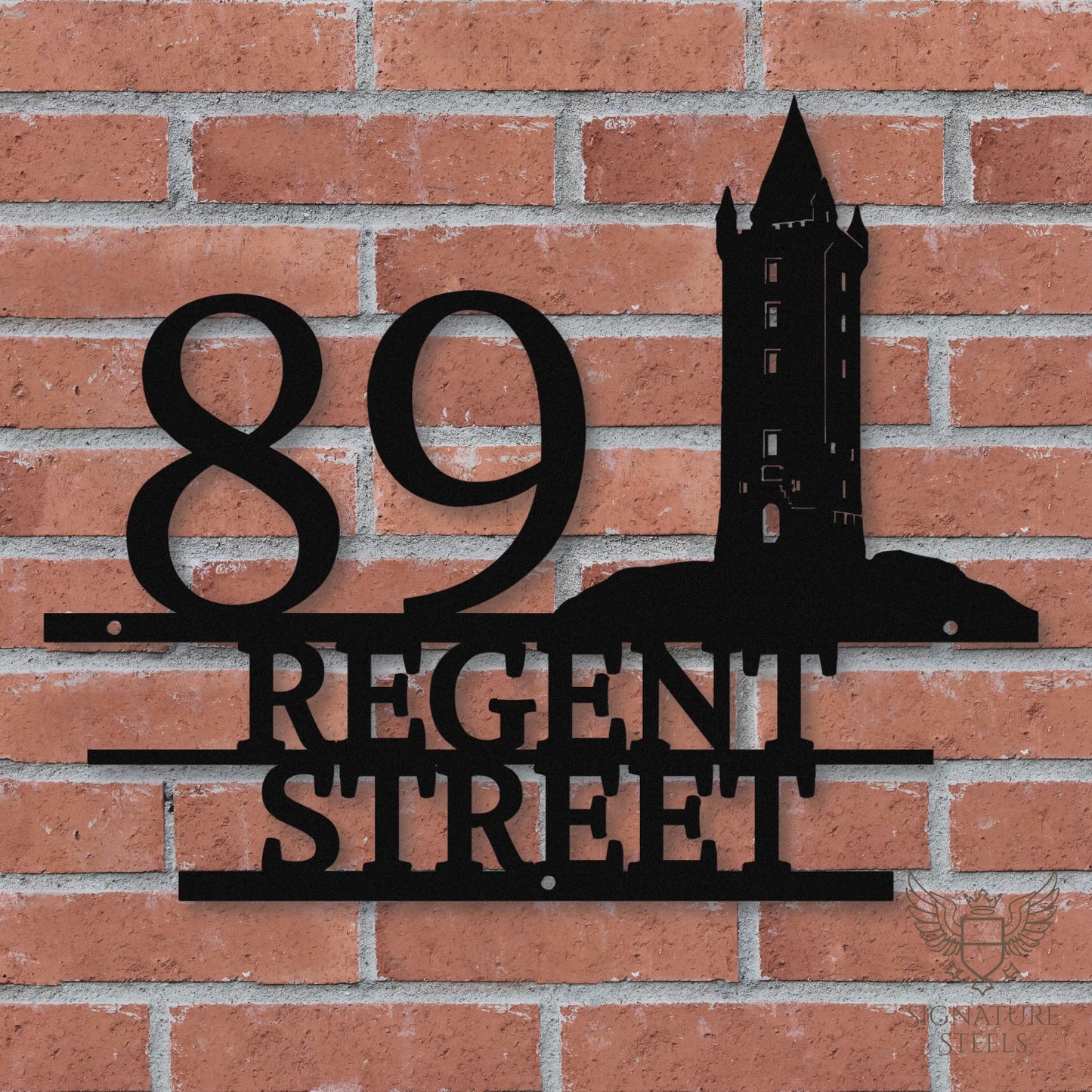 Black metal address sign with house number 89, street name Regent Street, horizontal parallel lines and a silhouette of Scrabo Tower, a landmark of Newtownards in Northern Ireland, hanging on a red brick wall.